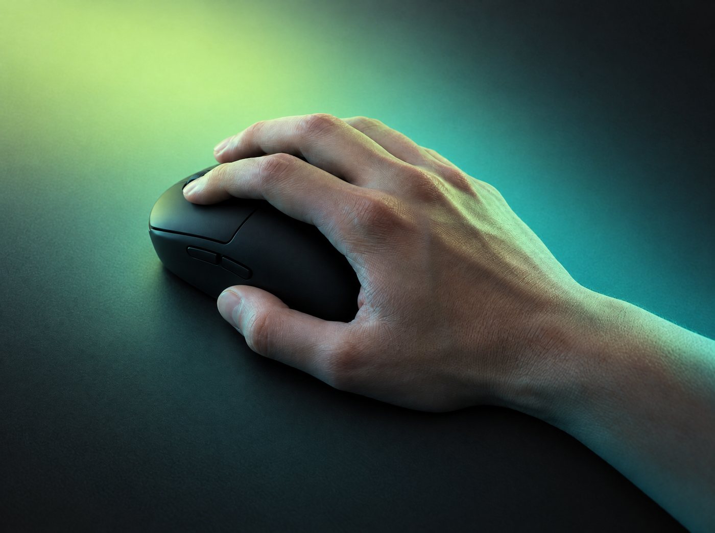 A hand resting on a black mouse in a palm grip